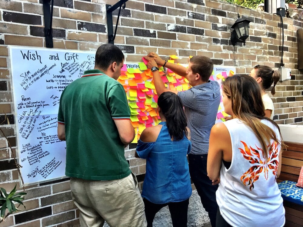 People pinning colorful notes to a board in support of charity work