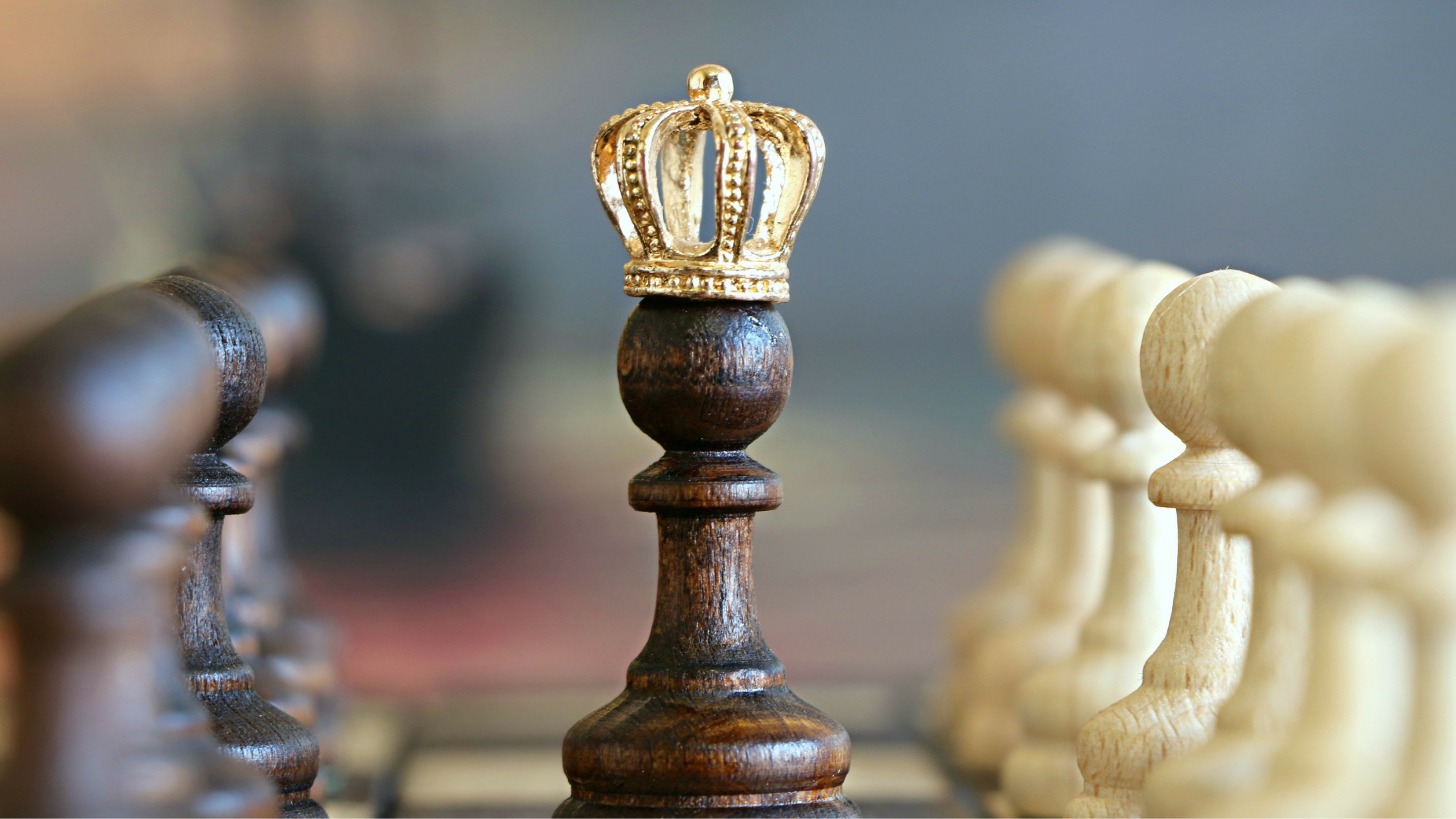 chess piece wearing crown surrounded by other pieces