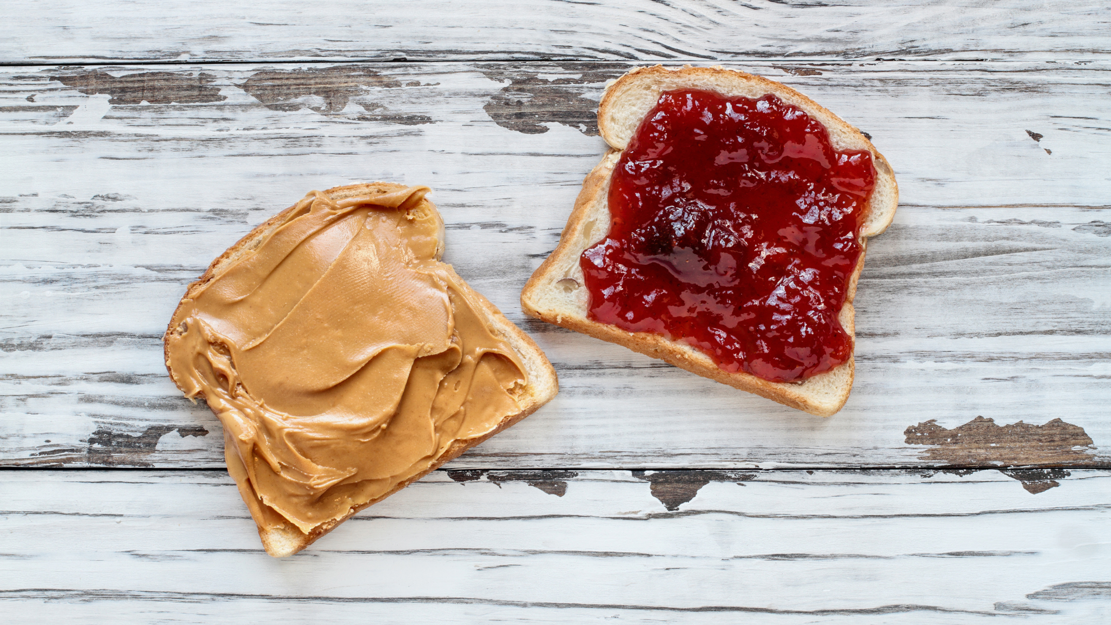 two pieces of bread one with peanut butter and one with jelly