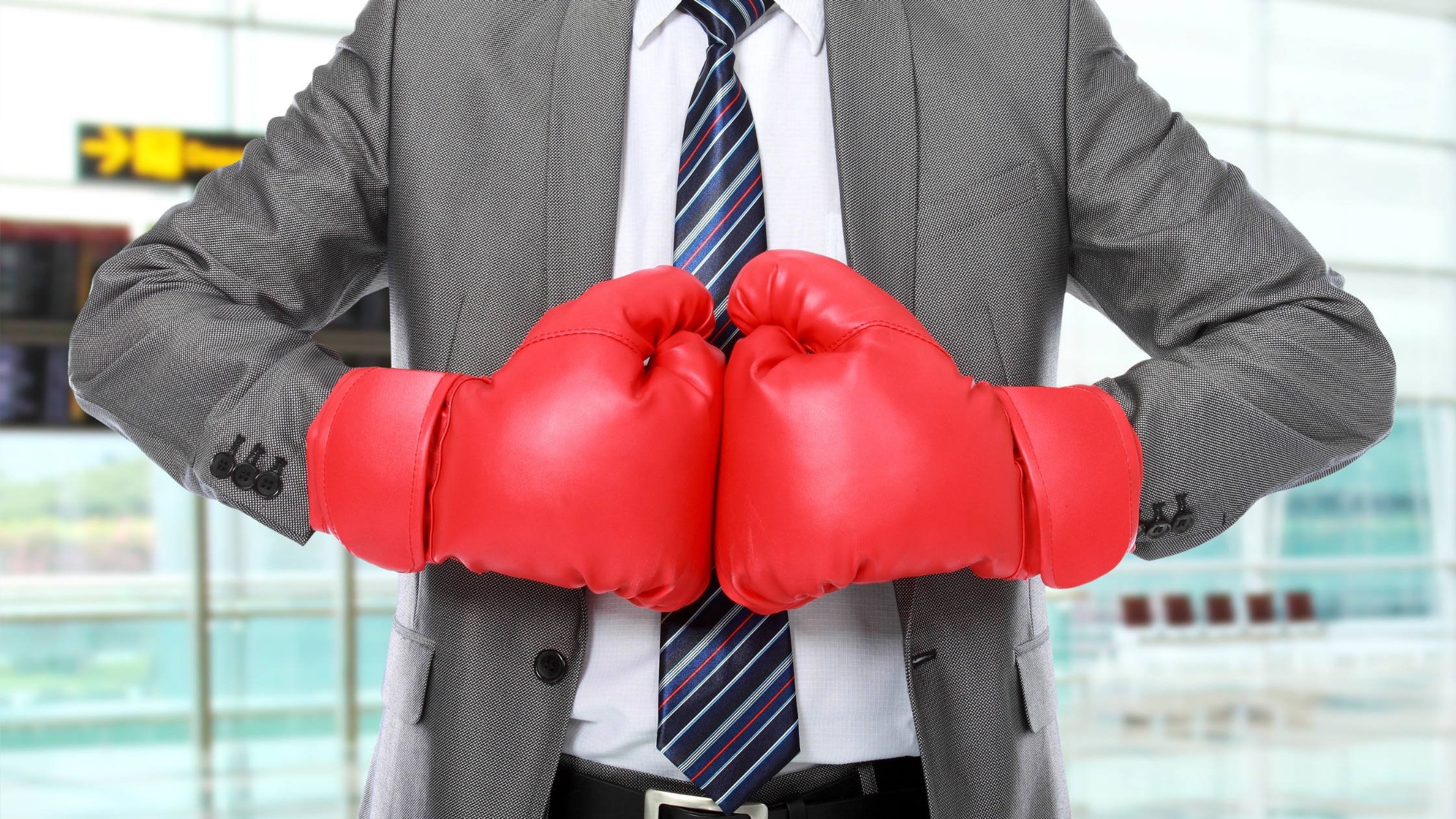 man in business suit wearing boxing gloves